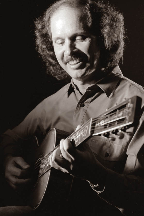 Dr. Tommy Comeaux playing a guitar