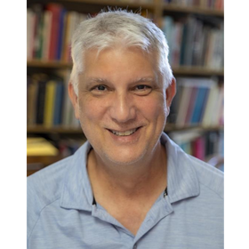 Headshot: John Laudun is pictured in his office wearing a light blue polo shirt.