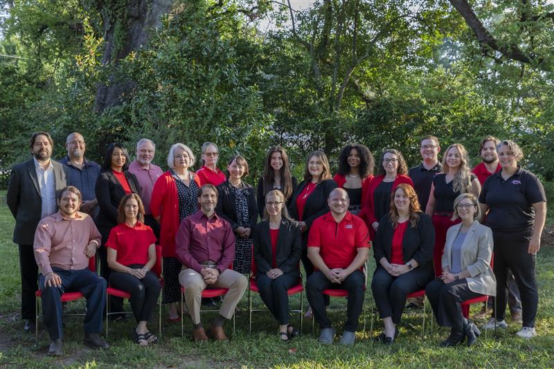 Office of Distance Learning staff members are pictured outdoors in three rows. The office currently has 22 employees.