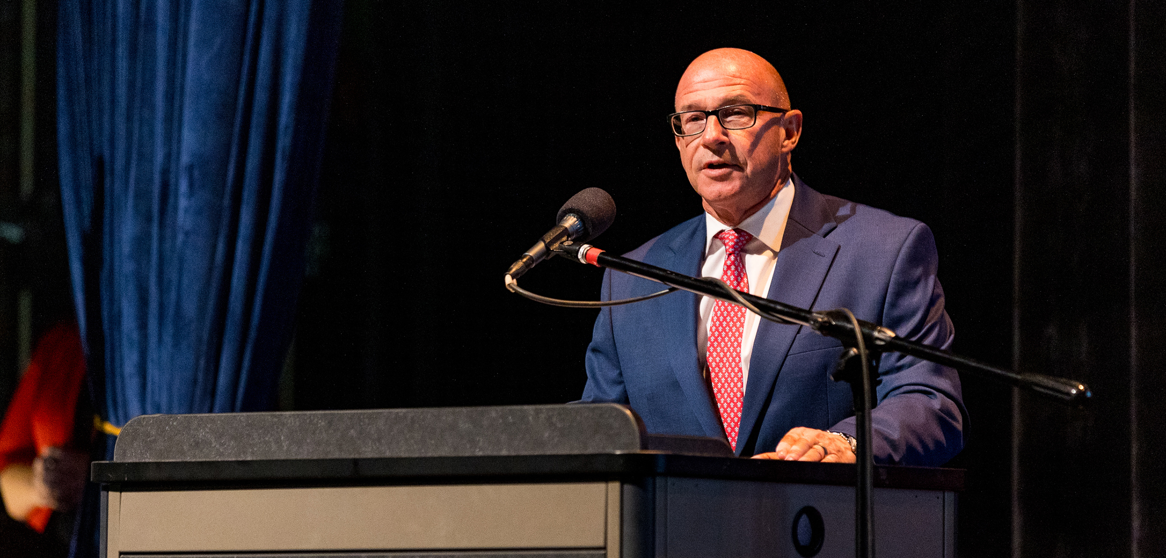 Dr. Hebert speaks at a podium on stage