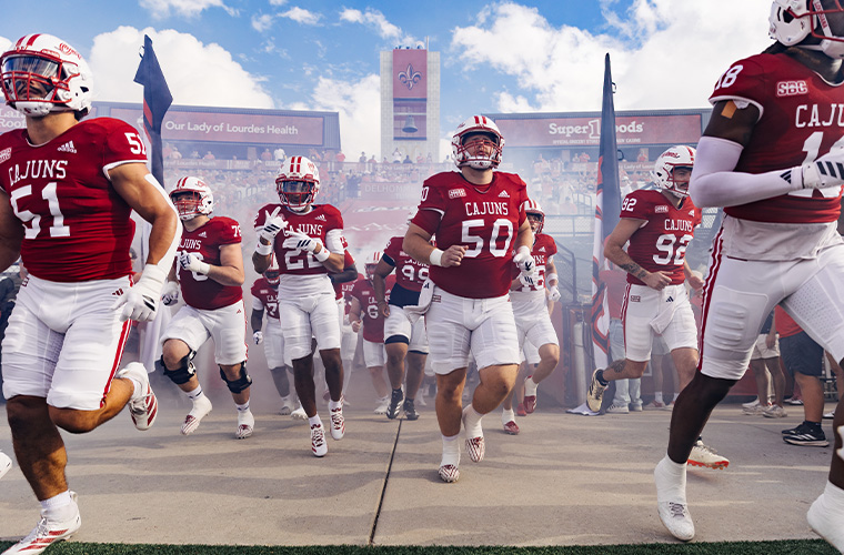 UL Lafayette football players entering the field through fog.