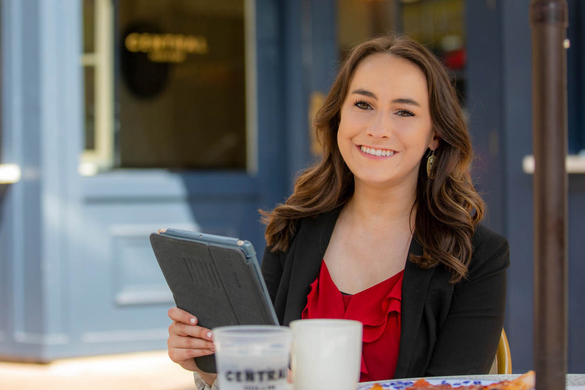 Online health care administration student works on tablet while sitting at a local restaurant. 