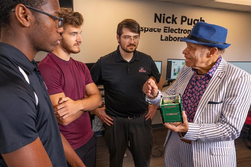 Dr. Magdy Bayoumi speaks with three students.