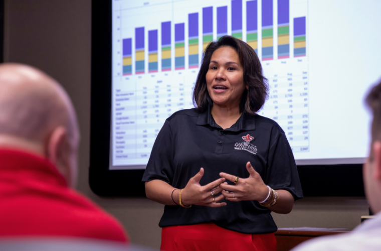 Online MBA in Finance graduate delivers a fiscal presentation. 
