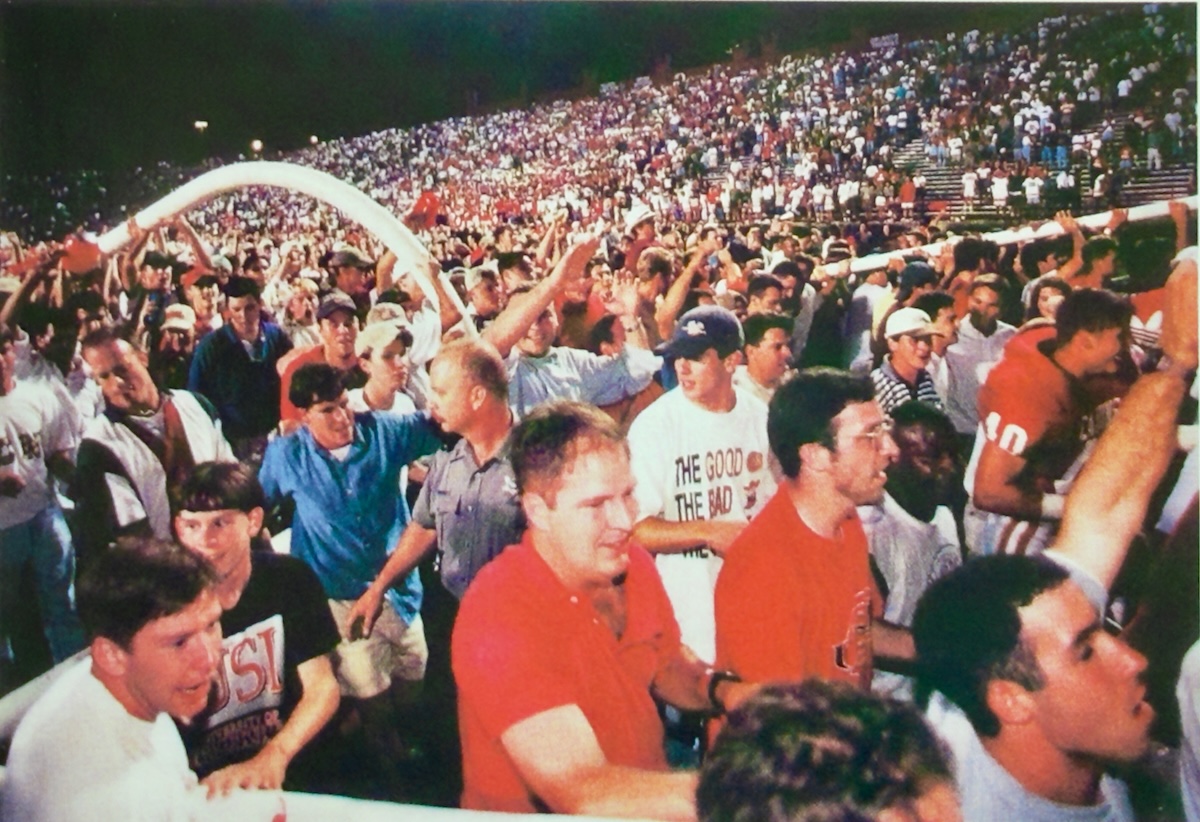 In an archive photo from 1996 a crowd of people at Cajun Field take down a football goal post.