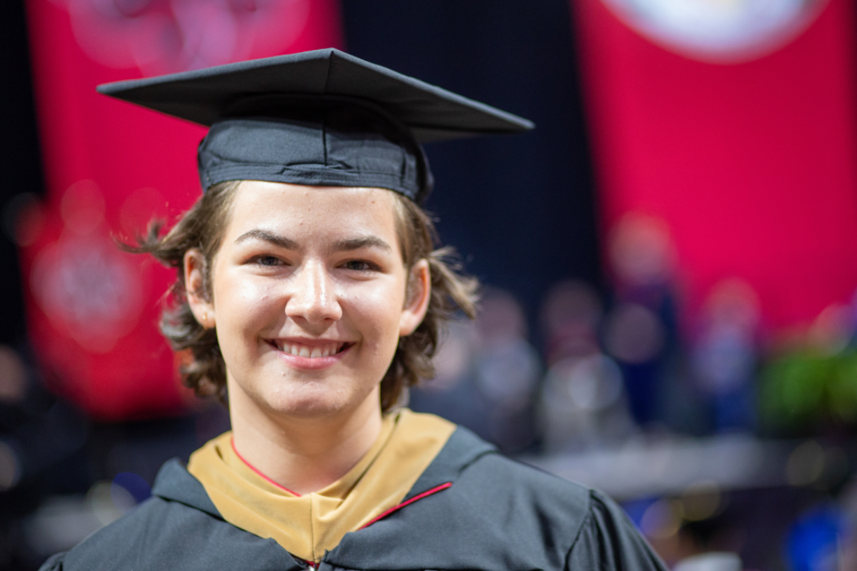 M.S. in Accounting graduate Debra Crawford smiles during commencement ceremonies. She's wearing black, UL Lafayette commencement regalia.