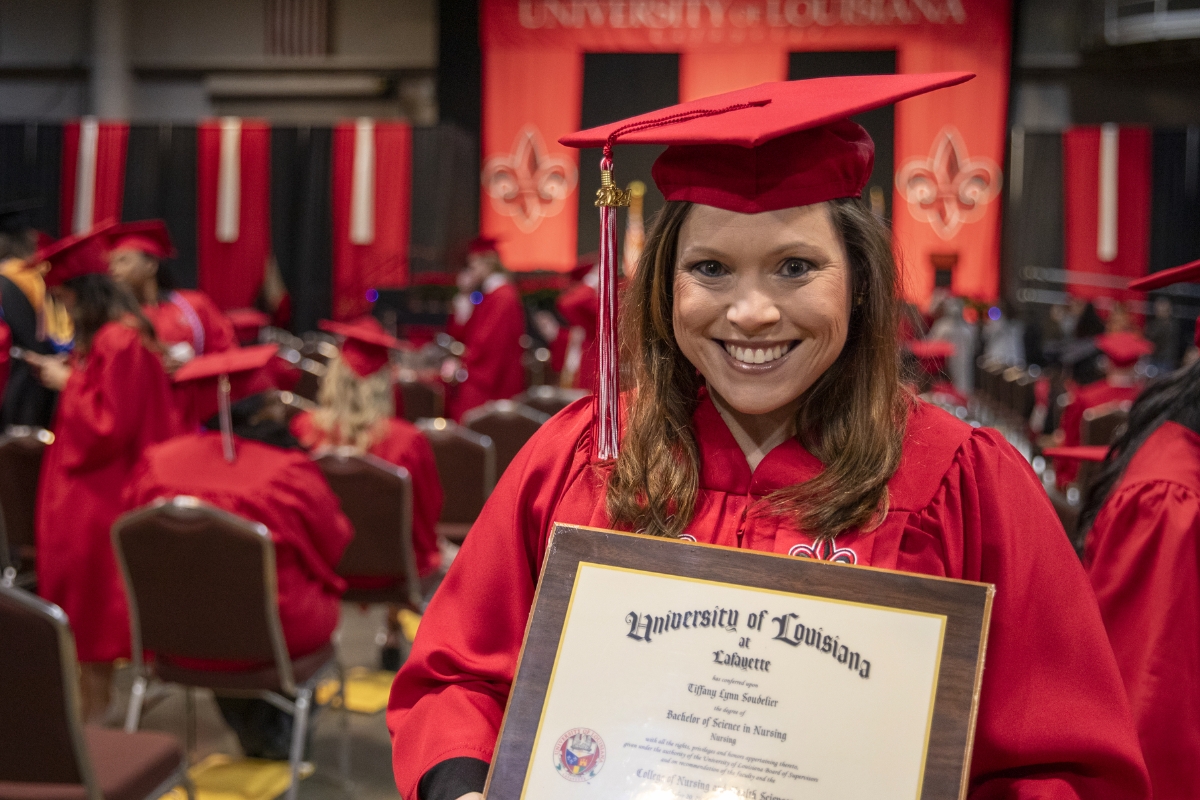 RN to BSN graduate Tiffany Soudelier smiles at Commencement while holding her University diploma.