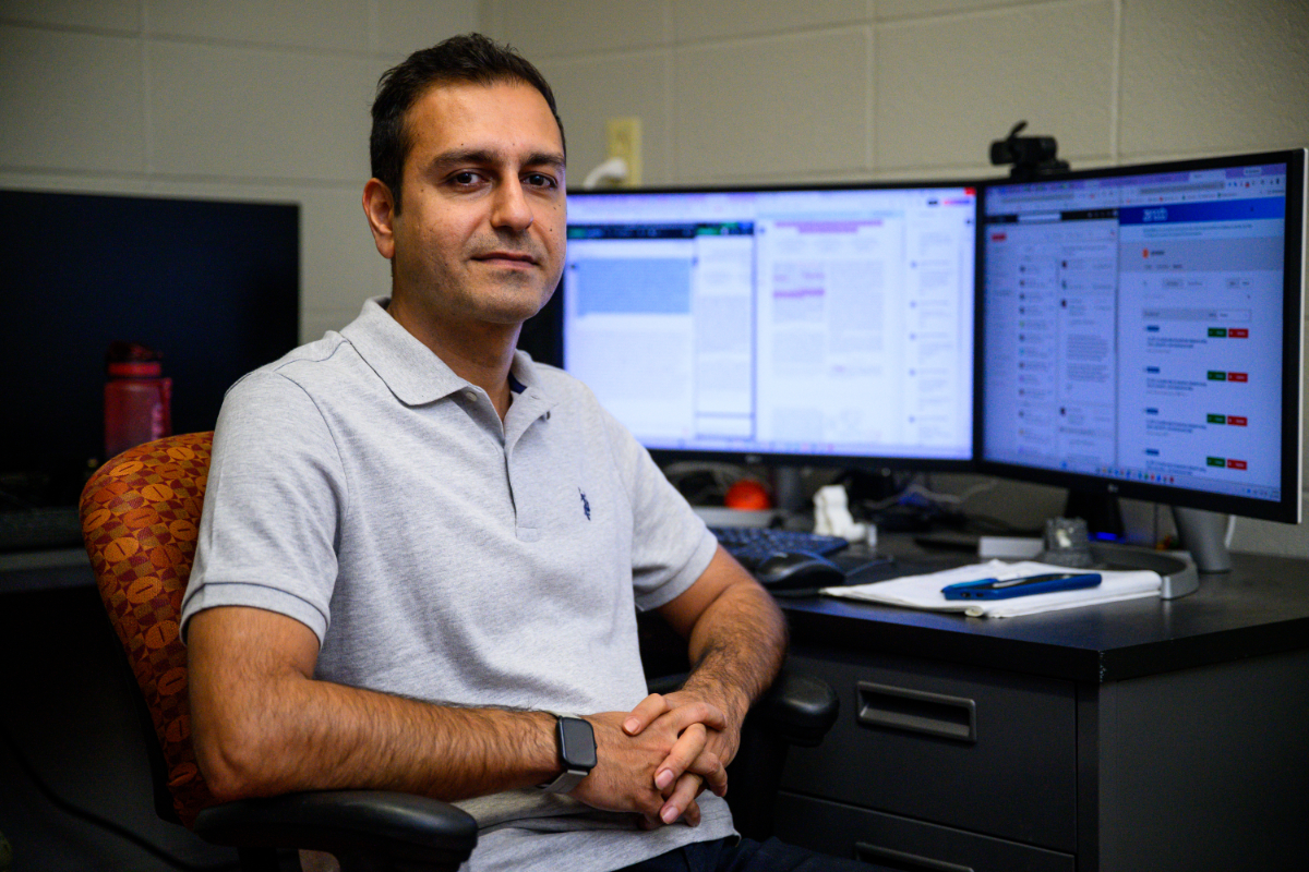 Portrait photo of Morteza Bodaghi sitting at a computer desk with his hands crossed wearing a polo shirt.