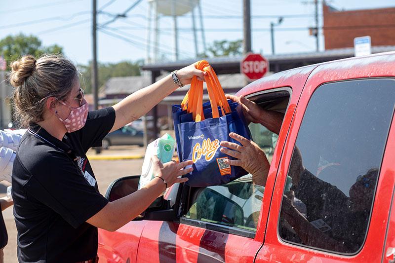 A UL Lafayette student hands donated groceries to a Louisiana resident in need