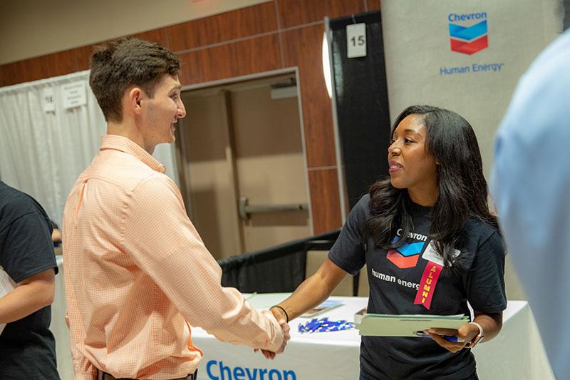 A University of Louisiana at Lafayette student shakes hands with a recruiter at a university career fair
