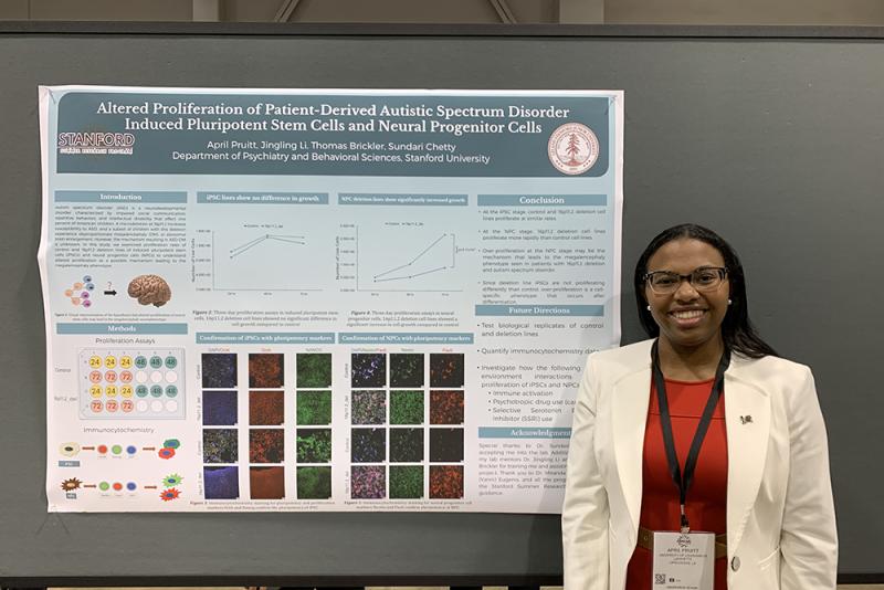 April Pruitt standing in front of her biology research presentation poster