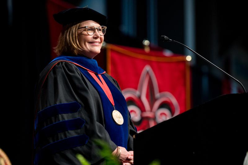 Dr Farmer-Kaiser on stage during the hooding ceremony speaking at the podium