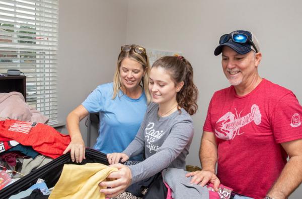 A freshman Louisiana at Lafayette student unpacking her dorm room with her parents