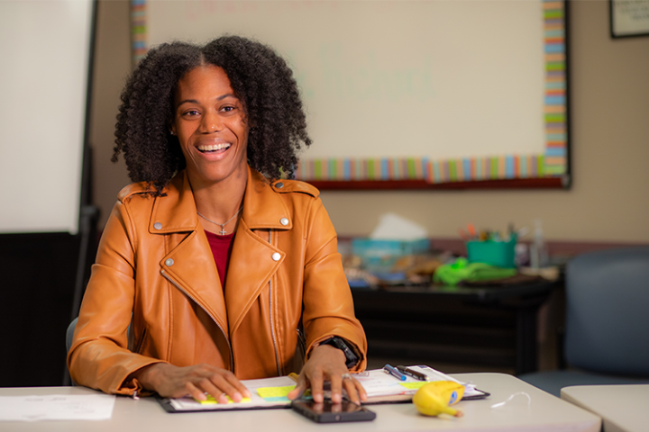 Health Promotion & Wellness degree online alumna Terri Roberts smiles across a conference table in the Foundation for Wellness offices.