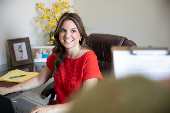 Alum of the online informatics program smiles while working at her desk.