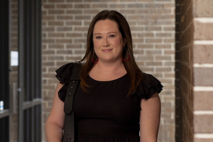 Taryn Cain, alumna of UL Lafayette's online Bachelor of General Studies, smiles for a portrait as she walks into work.