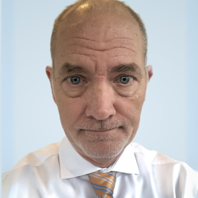 David Maynor smiles for headshot wearing a white button-up and a yellow and gray striped tie.