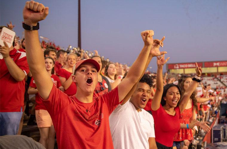 Students at a UL Lafayette football game cheering in the stands