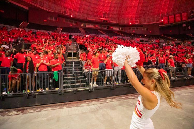 Cheerleader leading chants for students in the Cajundome at New Student Convocation