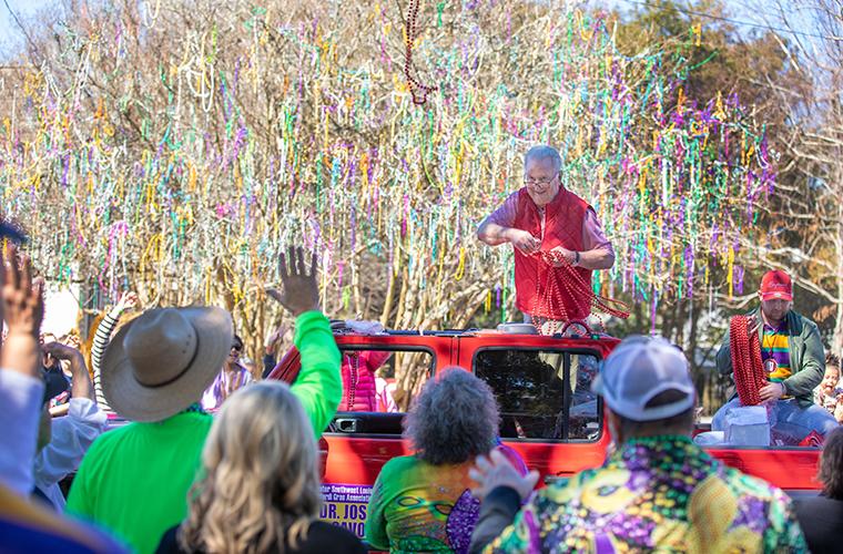 Dr. Savoie throws beads to the crowds at Lafayette's Mardis Gras