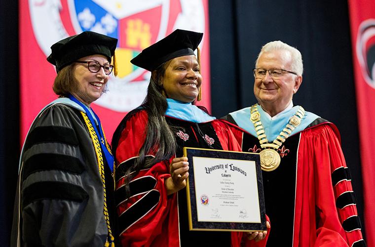 Dr. Savoie smiles at a doctoral student at Commencement