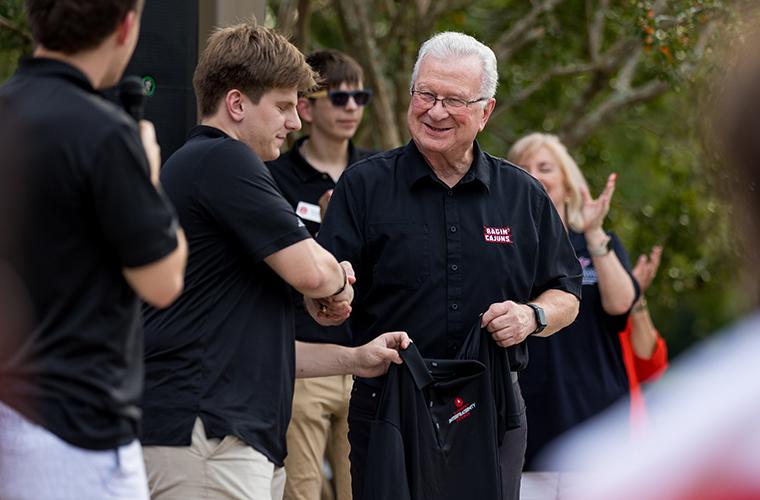 Dr. Savoie shaking a students hand