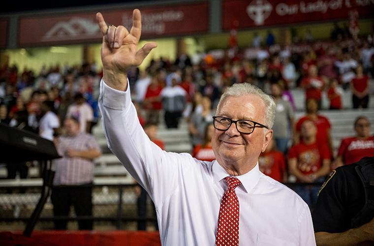 Dr. Savoie showing UL hand sign at Ragin' Cajuns football game on Cajun Field