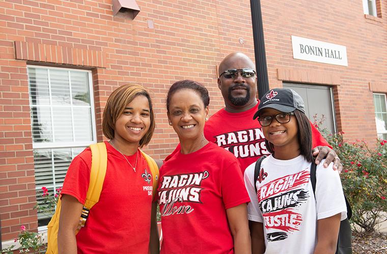 UL Lafayette freshman poses with family in front of dorm on move-in day