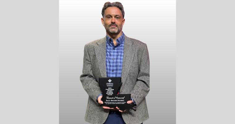 Tanner holding his plaque award.