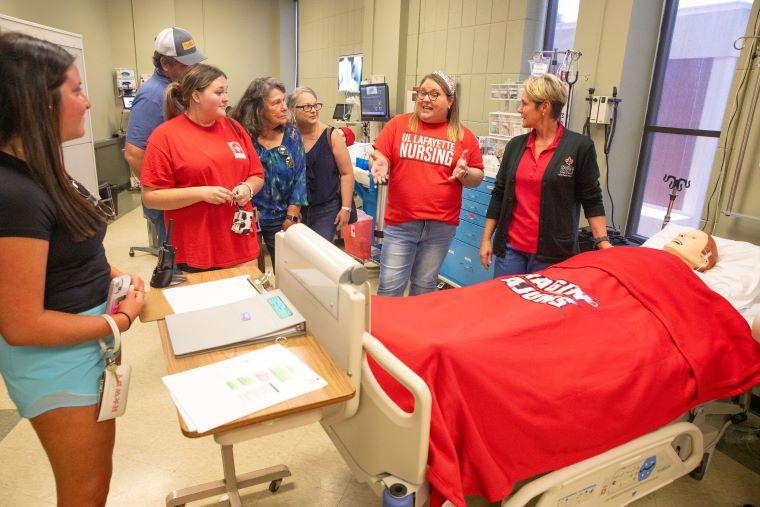 Nursing instructors show students and their families around the nursing simulation lab
