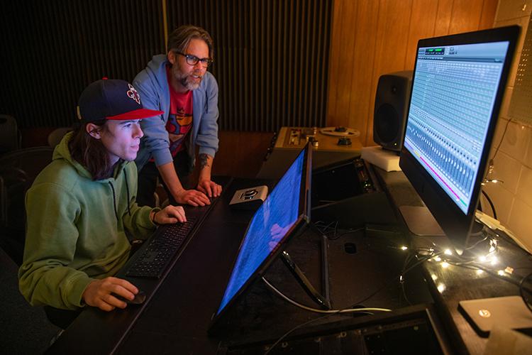 Student and professor at computer editing music files