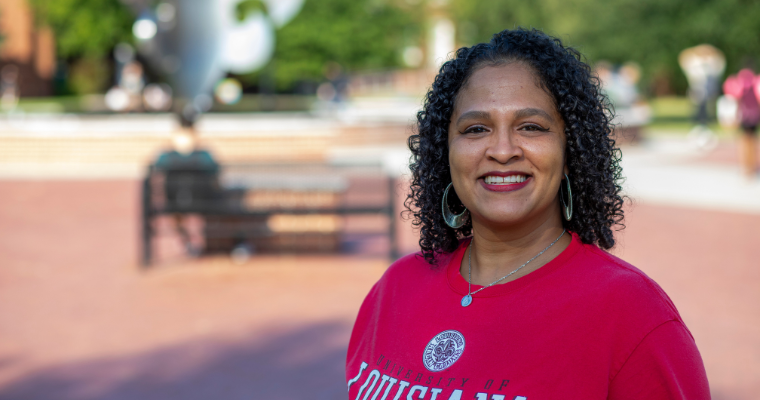 Dwan Alexander Cluse, academic advisor at UL Lafayette, smiles for a portrait in UL Lafayette's quadrangle.