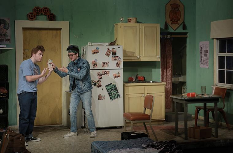 UL Lafayette students stand on a set designed to look like a rundown apartment in the 80s.