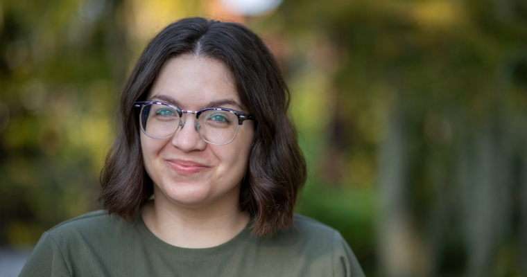 Megan Serio, academic advisor for UL Lafayette's online RN to BSN and Health Services Administration programs, smiles for a portrait in front of Cypress Lake on campus.