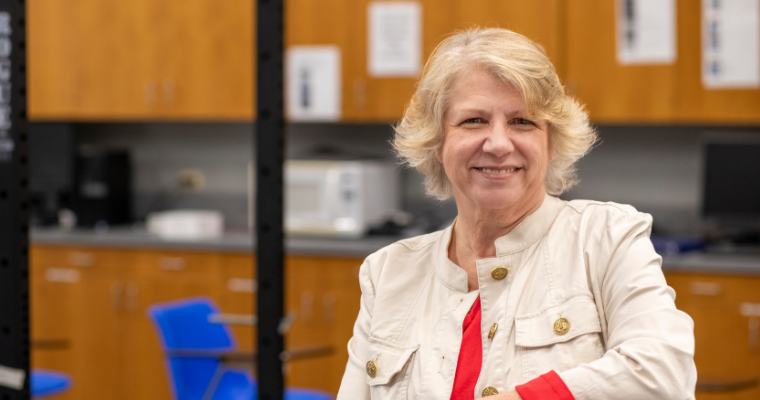 Lisa LeBlanc, master instructor and program coordinator for UL Lafayette's online bachelor's in health promotion & wellness, smiles for a portrait inside of a kinesiology classroom. 