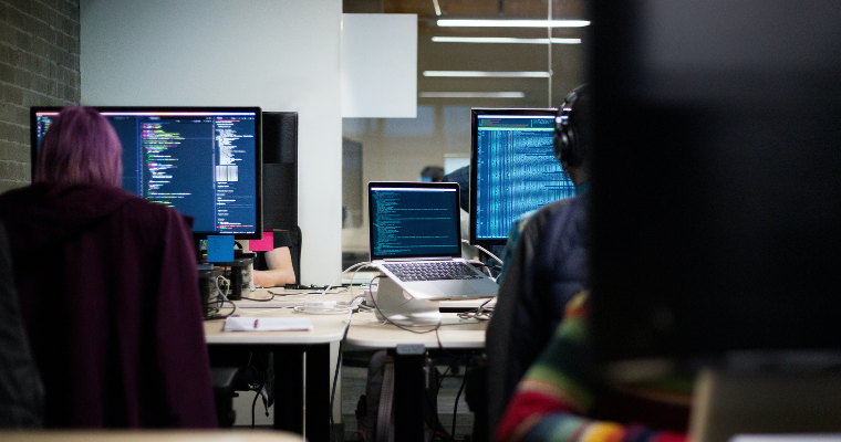 Online applied computing phd students work on coding in a computer lab. 