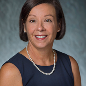 Portrait photo of Catherine Chauvin smiling and wearing pearls and a blue dress.