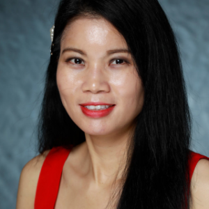 Portrait photo of Huong Nugyen smiling and wearing a red dress.