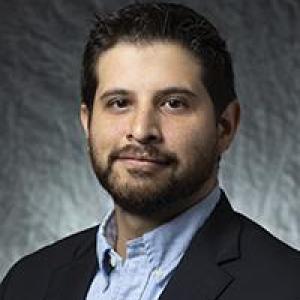 Portrait photo of Javier Portillo wearing a blue button down shirt and a navy blazer.