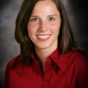 Portrait photo of Marguerite Blanchard smiling and wearing a red button down shirt