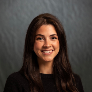 Headshot: Faith Derouen pictured on a gray background.
