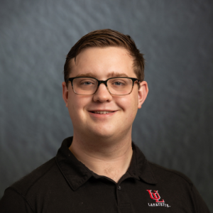 Headshot: Zachary Schleter pictured on a gray background.