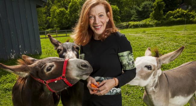 Author Susan Orlean surrounded by three donkeys