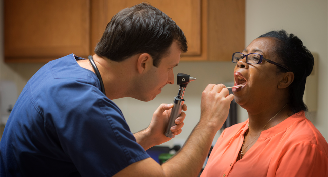 UL Lafayette MS in Nursing alumni and nurse practitioner Elliot Myers examines a patient in his St. Landry Parish clinic.