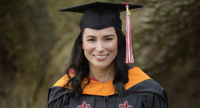 Tabitha Underwood, MSN, is pictured outdoors in a black, UL Lafayette graduate cap and gown.