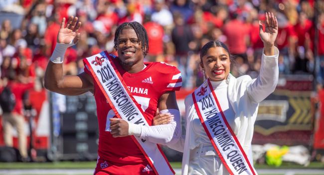 TJ Wisham is pictured in his football uniform and homecoming king sash with the 2021 homecoming queen. Wisham earned his MS in Systems Technology online from UL Lafayette.