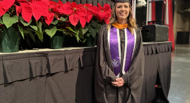 Dana Wallis stands near the commencement stage at the Cajundome Convention Center ahead of Fall 2023 graduation.