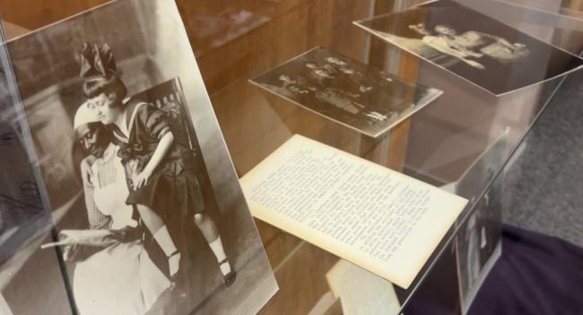 Black-and-white archive photographs in an exhibit case.