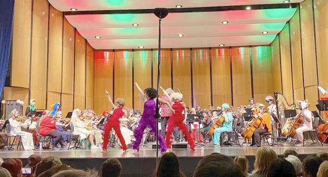Orchestra members perform in costume, along with dancers, at the annual Halloween concert.