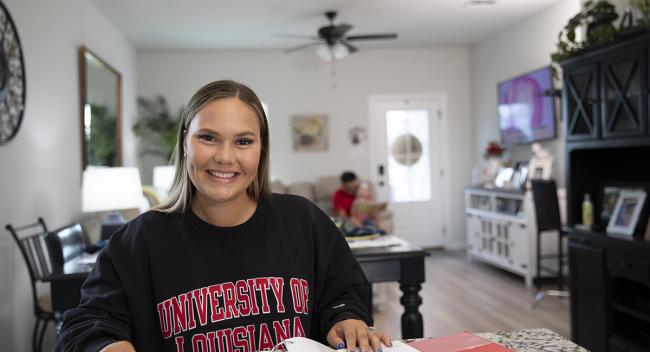 Student sits behind kitchen table